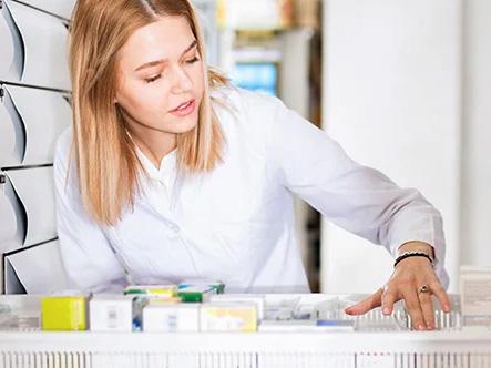 Pharmacist checking stock in a draw of her pharmacy